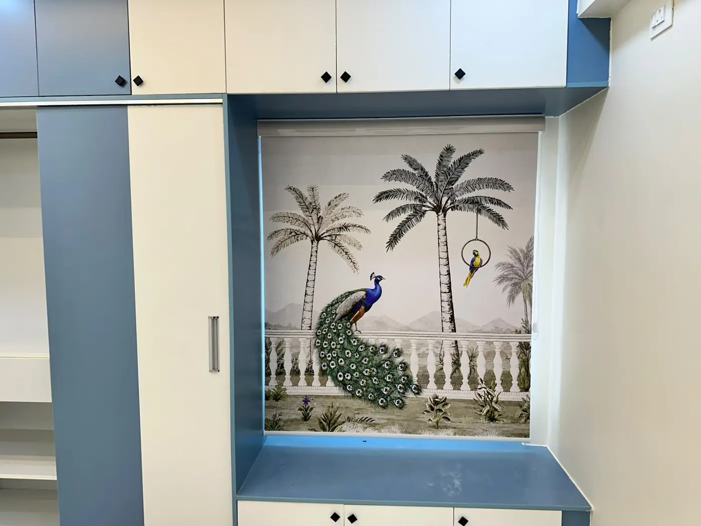 Printed roller blind with a peacock design in a window nook